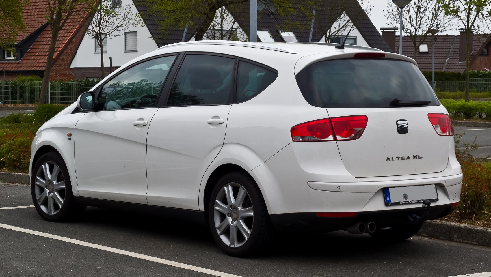 Rear and side view of a white compact MPV with alloy wheels and distinct rear lights