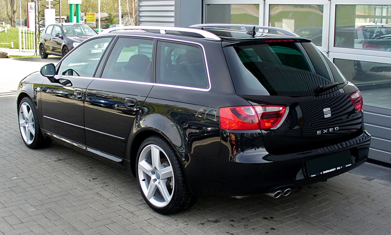 Sleek black estate rear and side with dual exhausts and roof rails