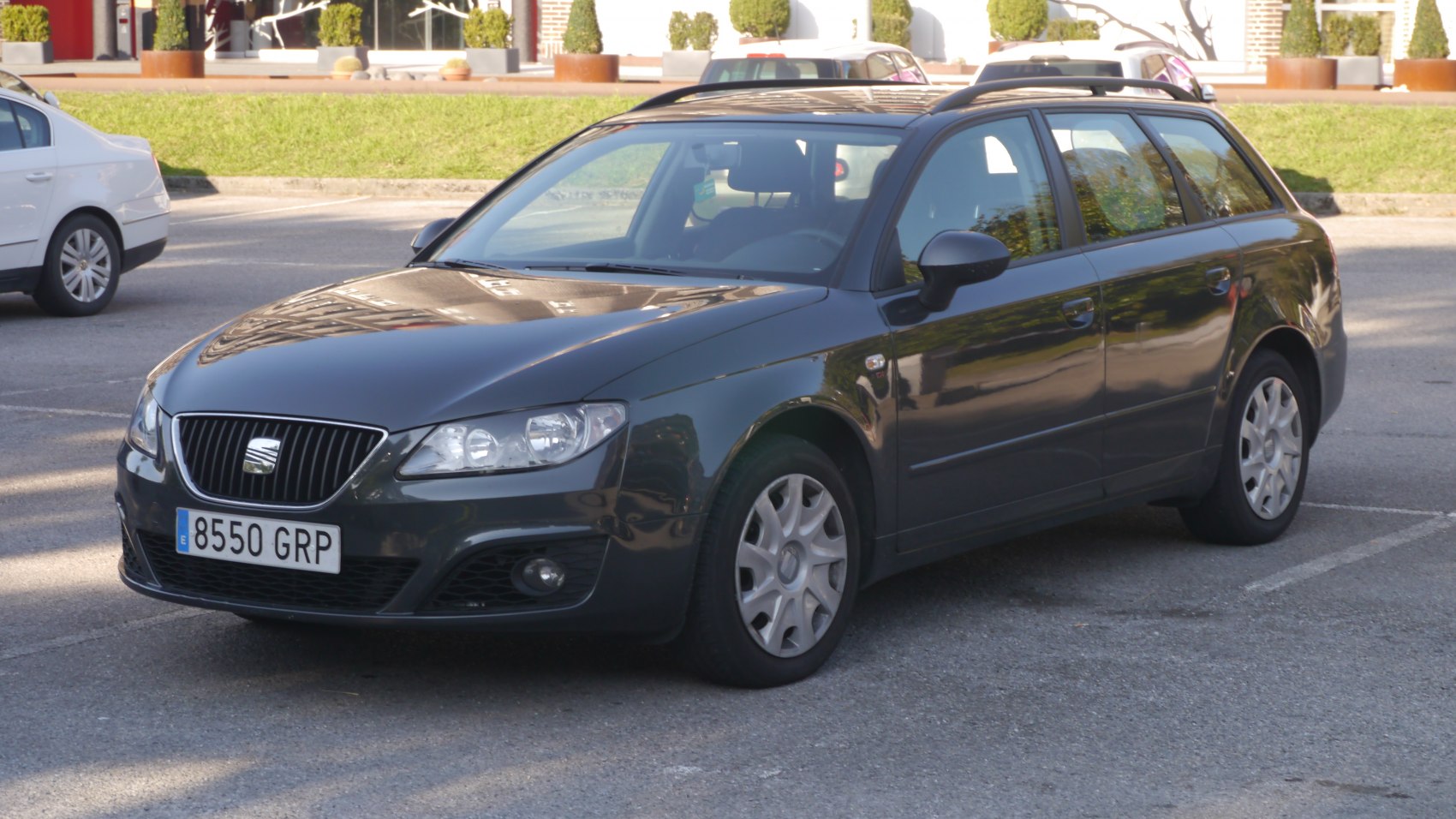 Black station wagon with front grille and roof rails in daylight