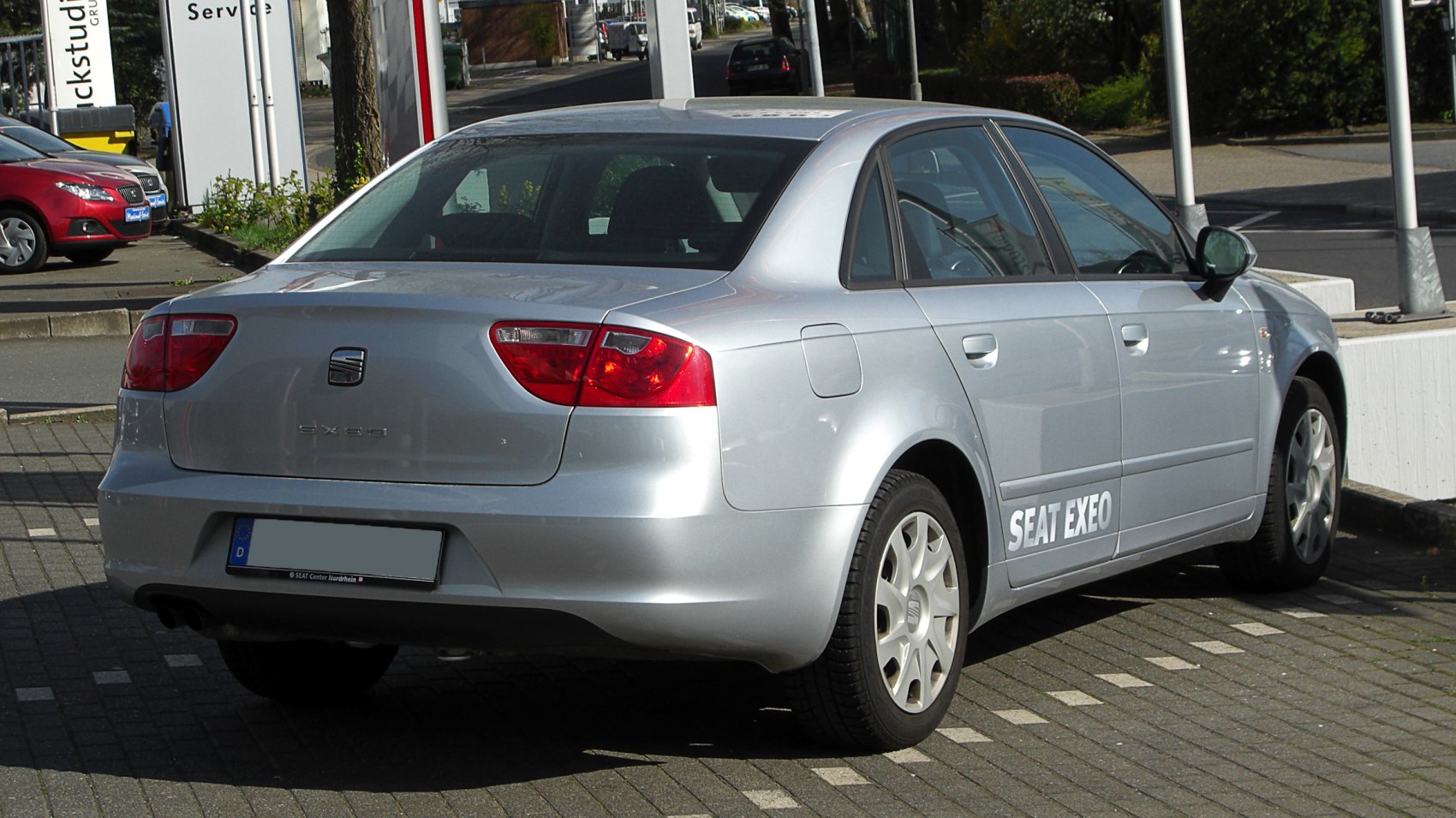 Rear three-quarter view of a silver mid-size sedan with distinct taillights
