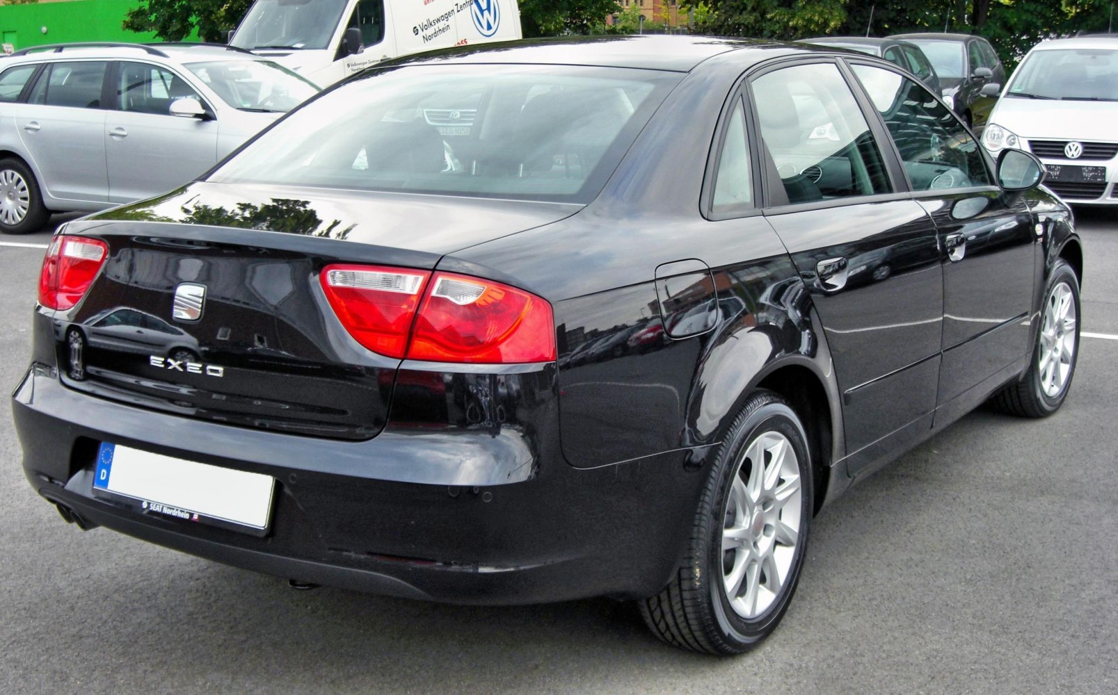 Rear view of black sedan with prominent taillights and alloy wheels