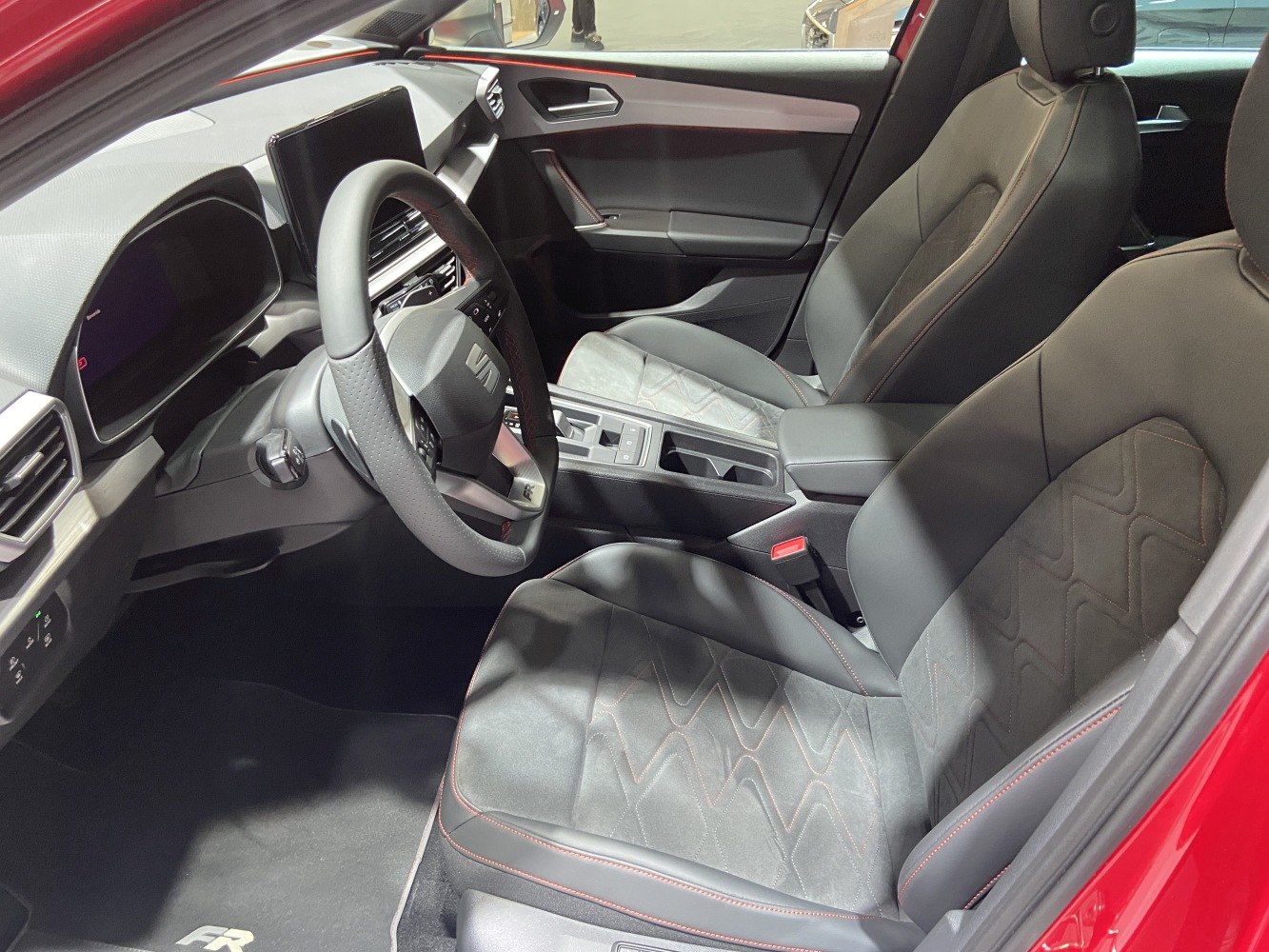 Modern dashboard with digital display and sporty leather seats.