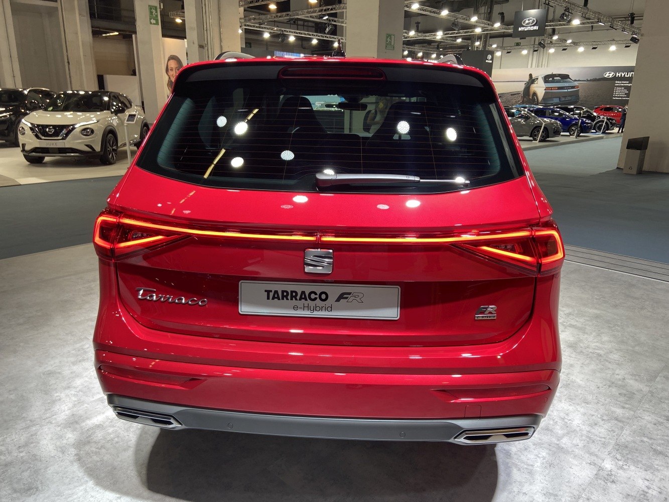 Rear view of a red modern e-Hybrid SUV with LED taillights and dual exhausts