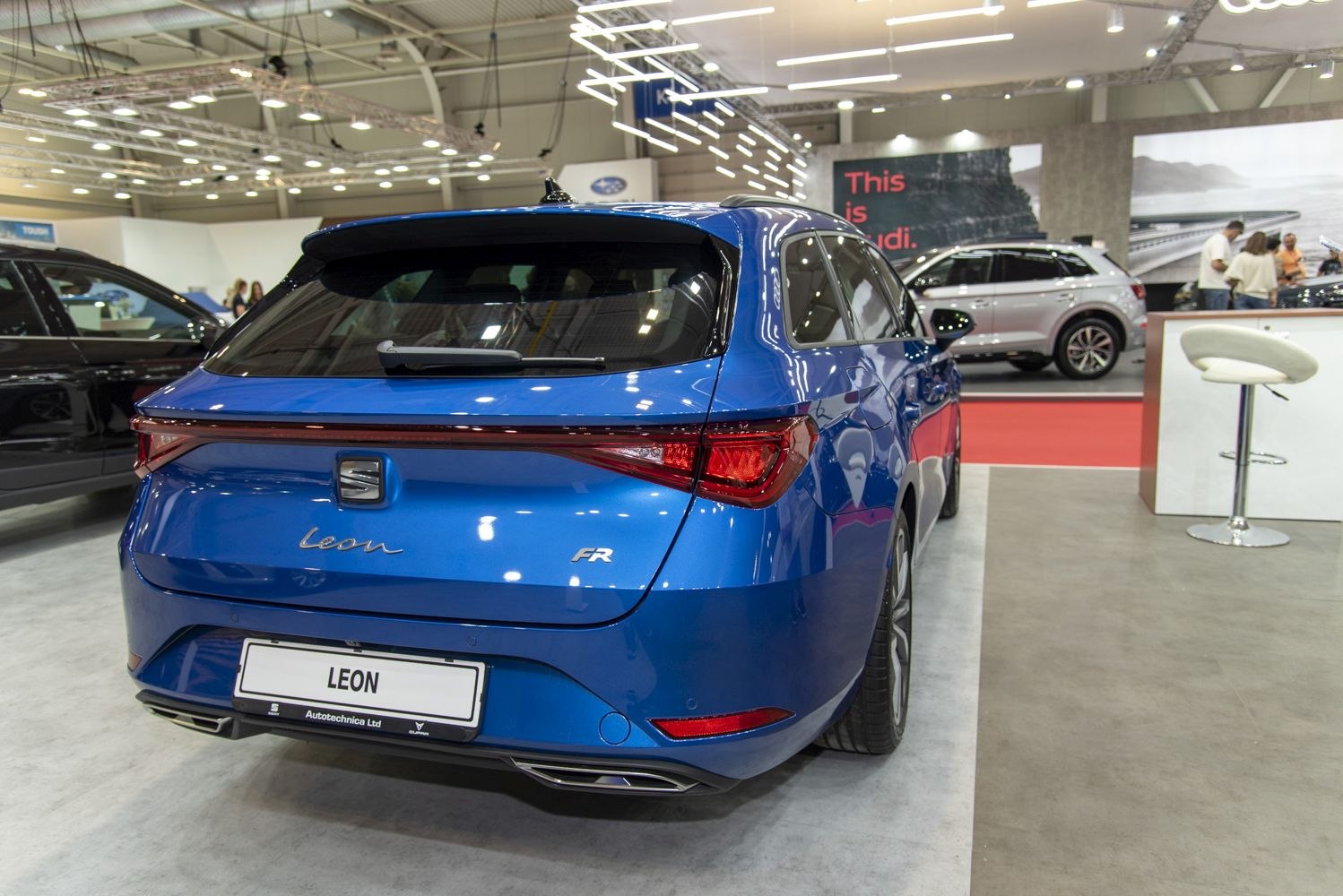 Rear view of a blue hatchback with LED taillights and dual exhausts