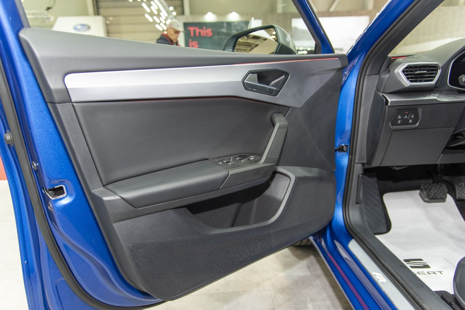 Driver-side interior door panel with controls and door handle