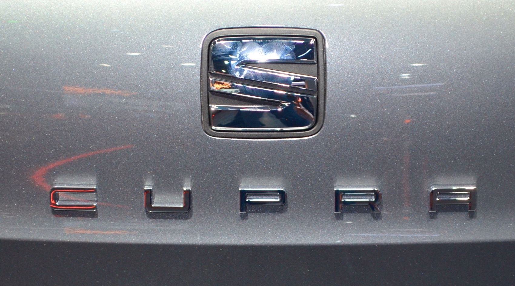 Close-up of a car emblem and CUPRA lettering on metallic surface