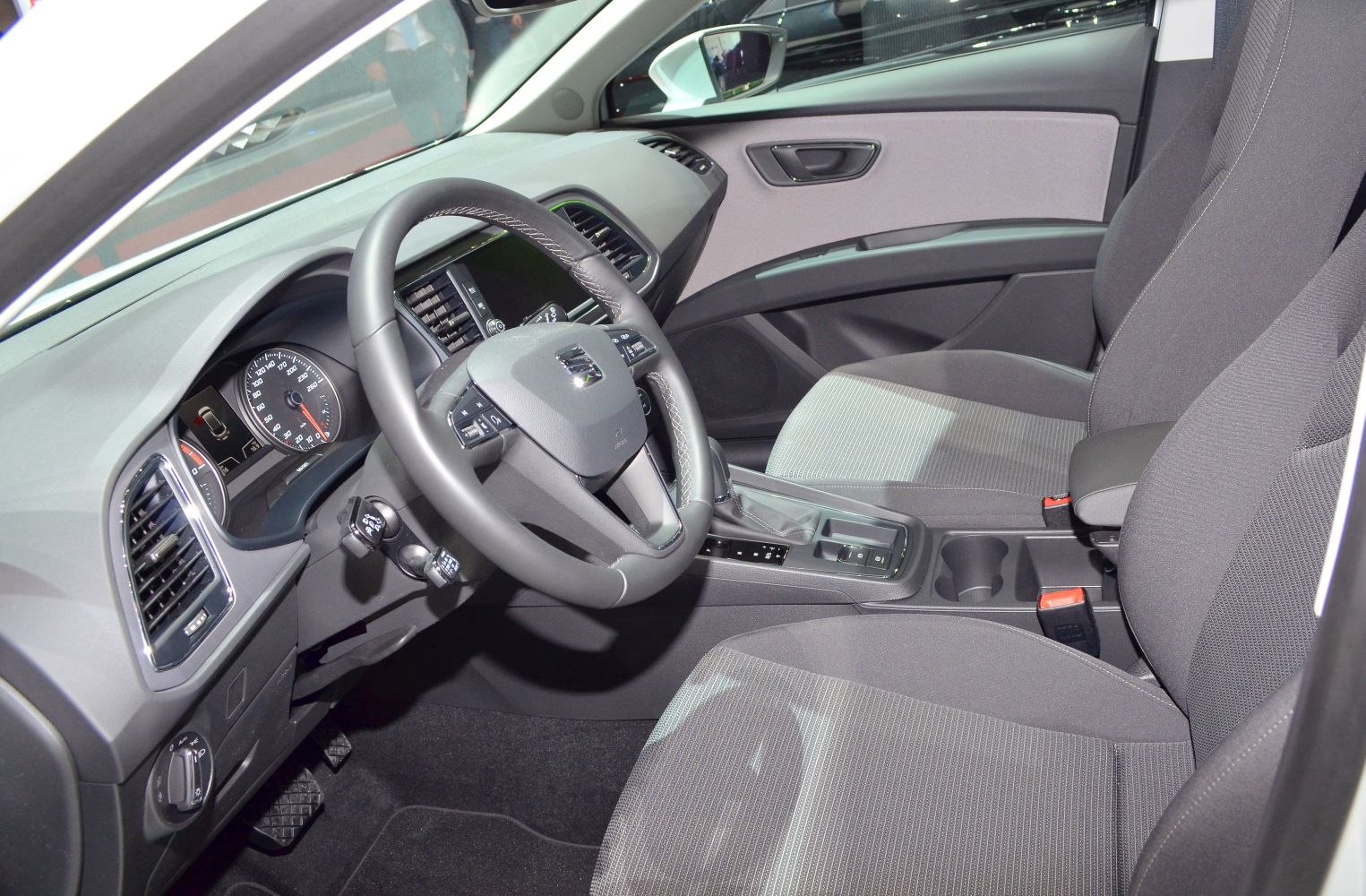 Steering wheel, dashboard, and front seats of modern car interior