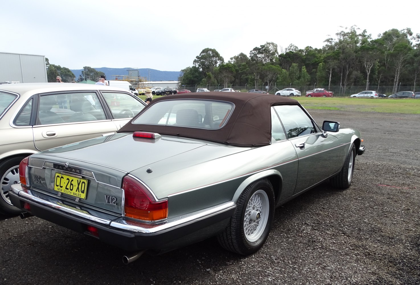 Rear view of convertible with soft top and intricate alloy wheels.