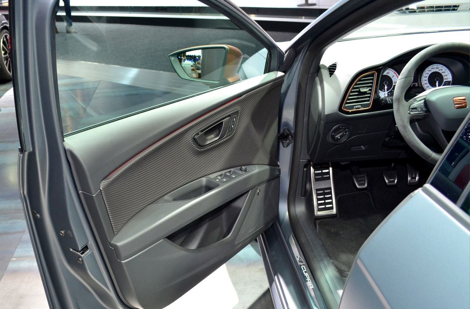 Driver's side door panel, pedals, and dashboard interior details.