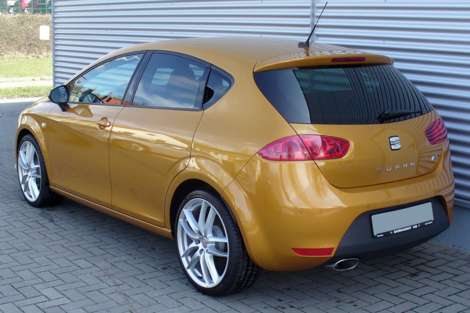 Golden hatchback with alloy wheels, tinted windows, and rear lights