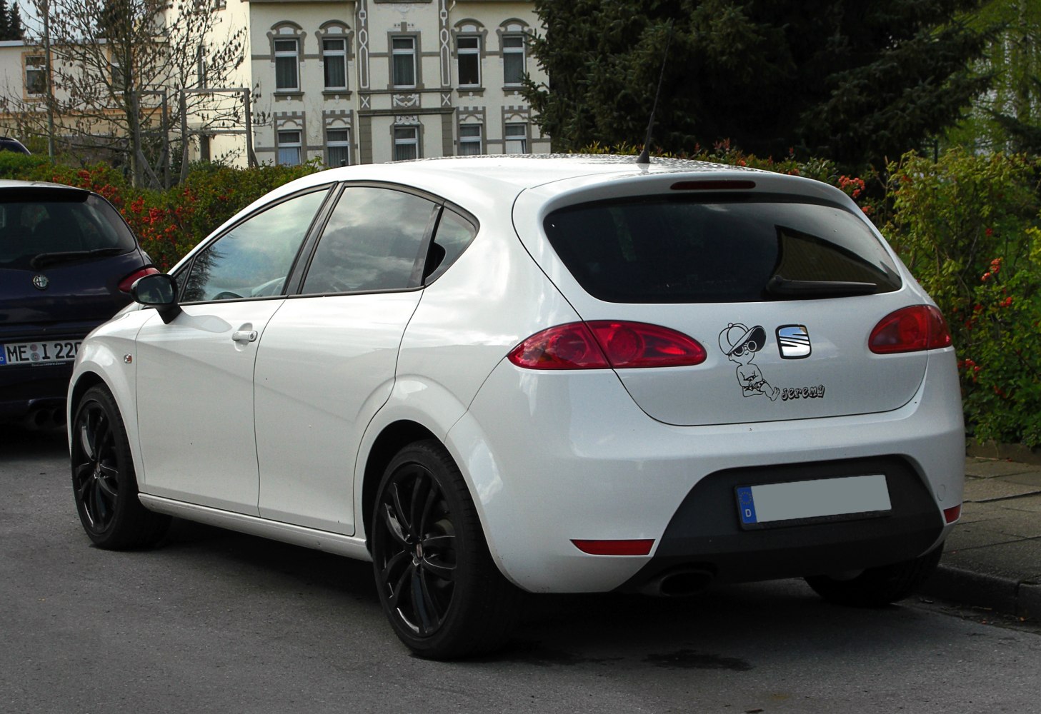 White five-door hatchback with black alloy wheels and rear decals