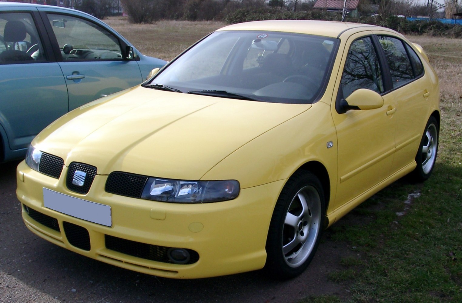 Yellow hatchback car front-side view with distinct grille and headlights