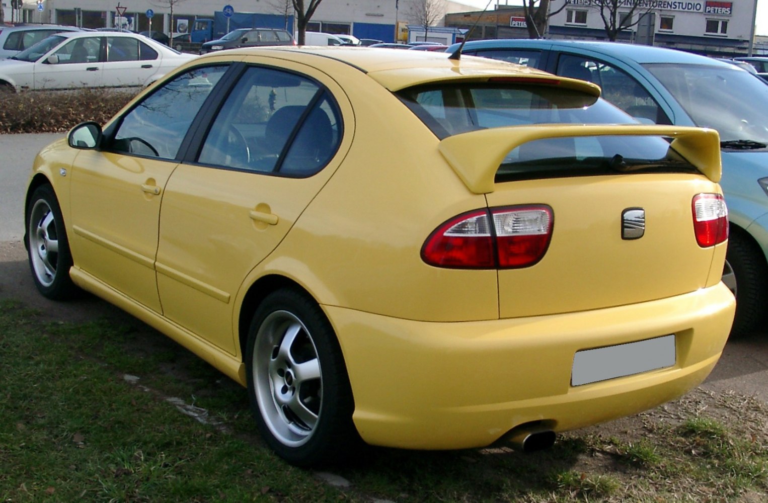Yellow hatchback with rear spoiler and alloy wheels