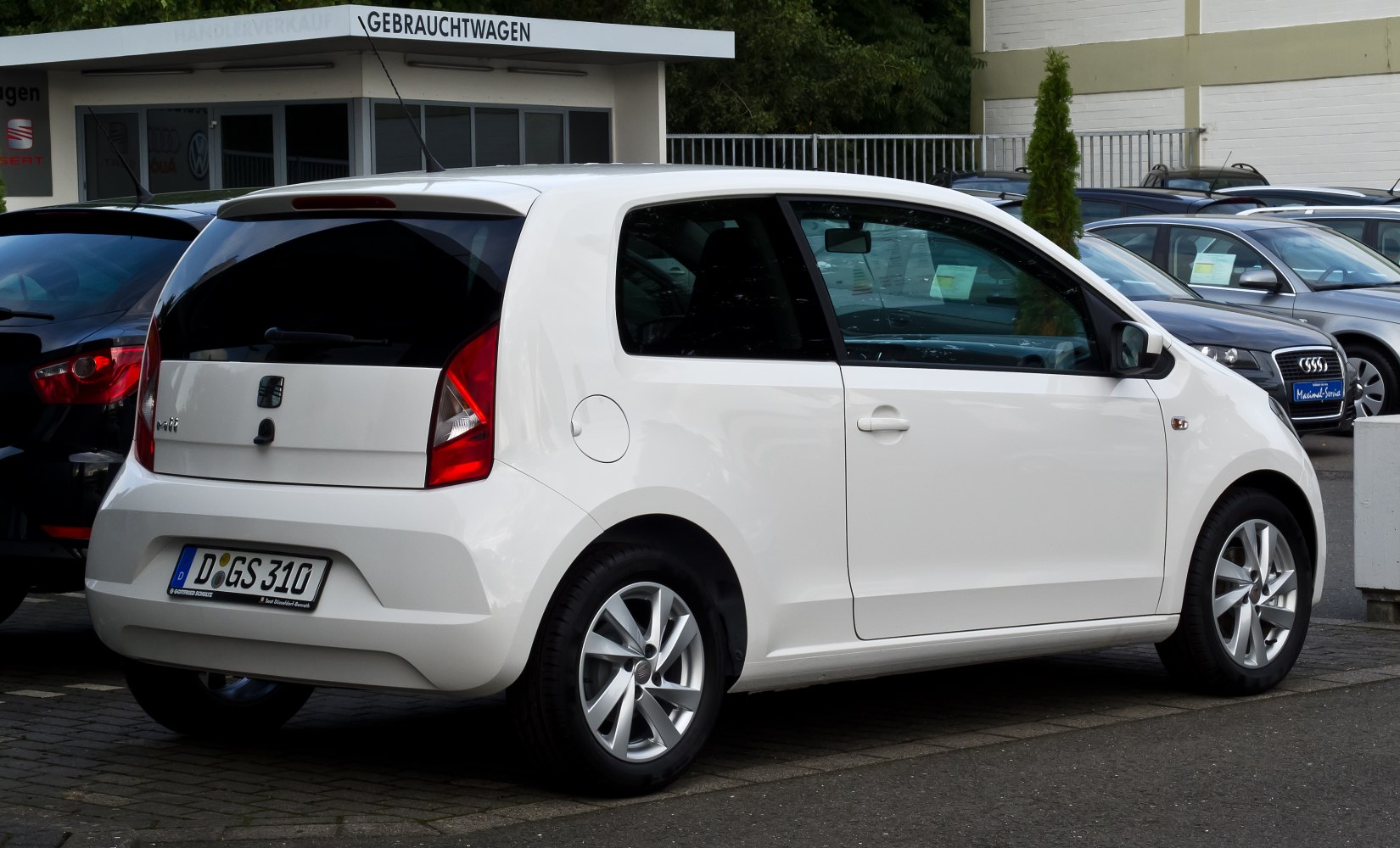 White compact hatchback with rear lights and alloy wheels.