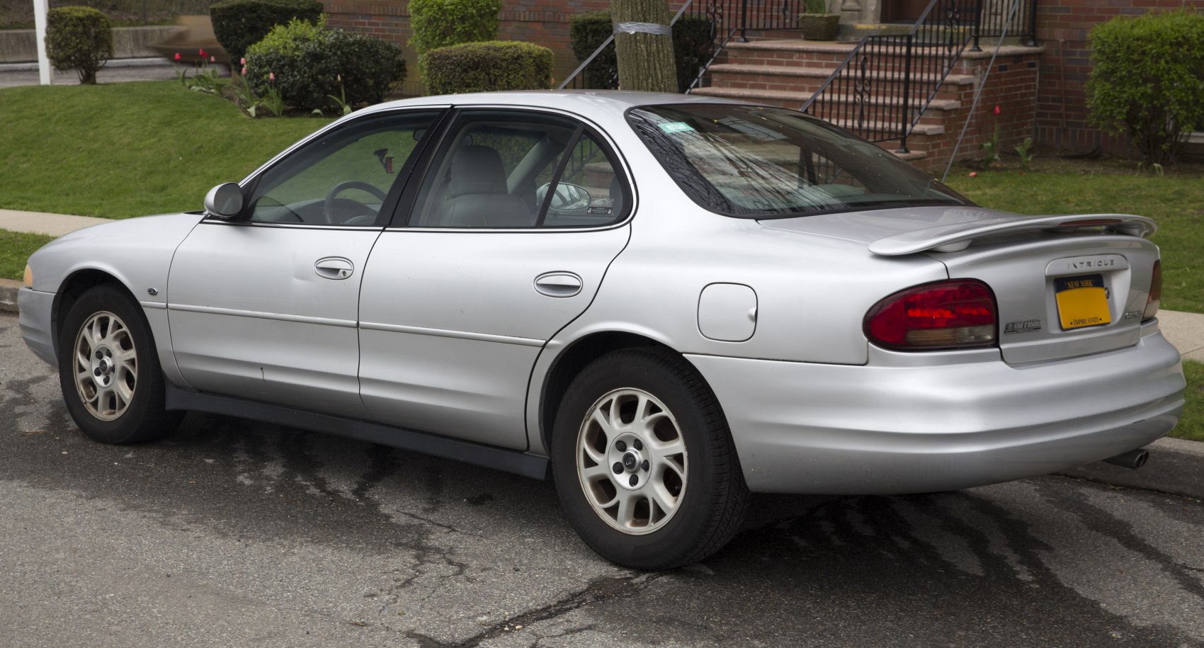 Rear side view of a sedan with spoiler and oval tail lights