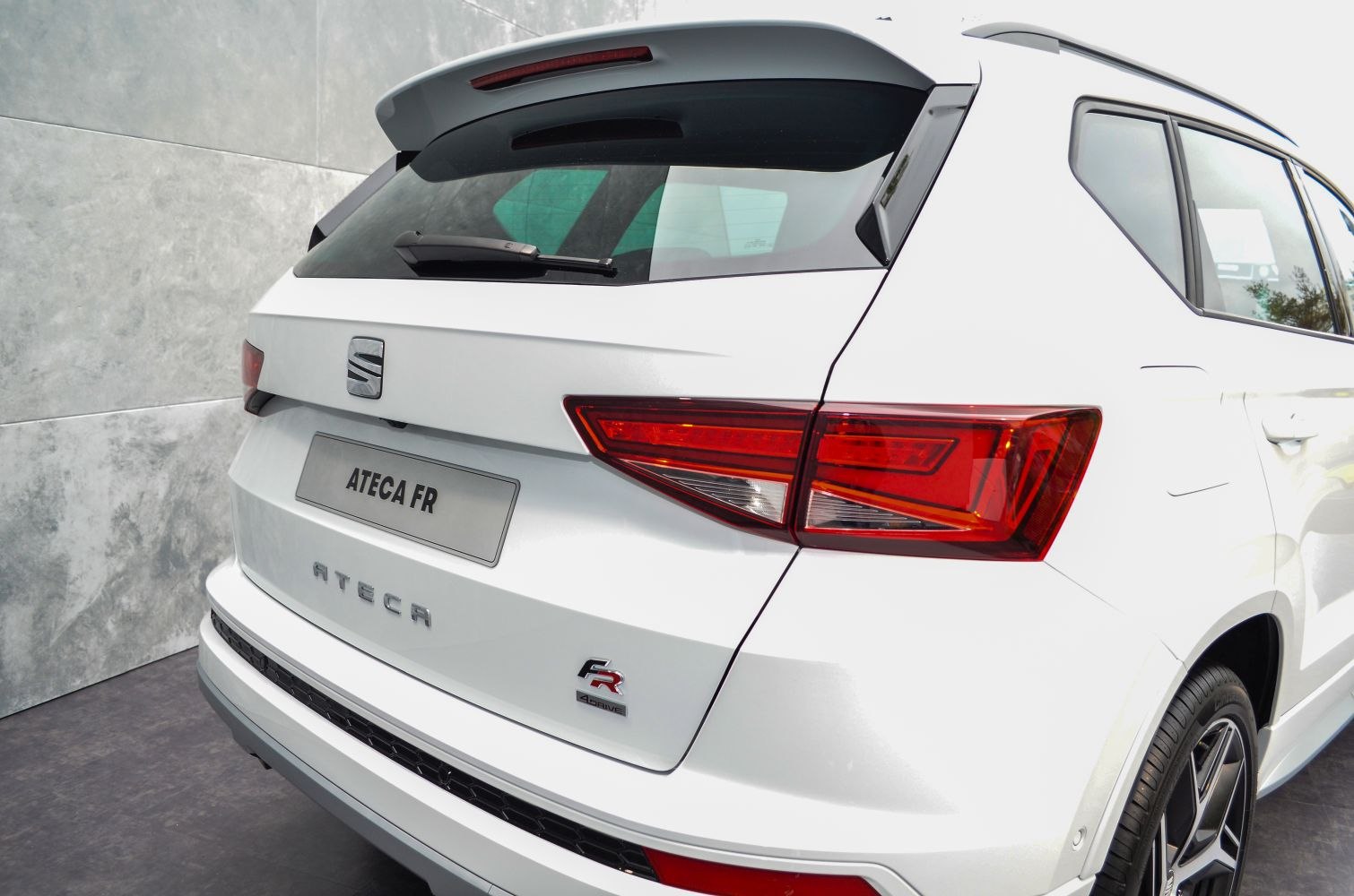 Rear view with angular tail lights, rear spoiler, FR badge on white SUV