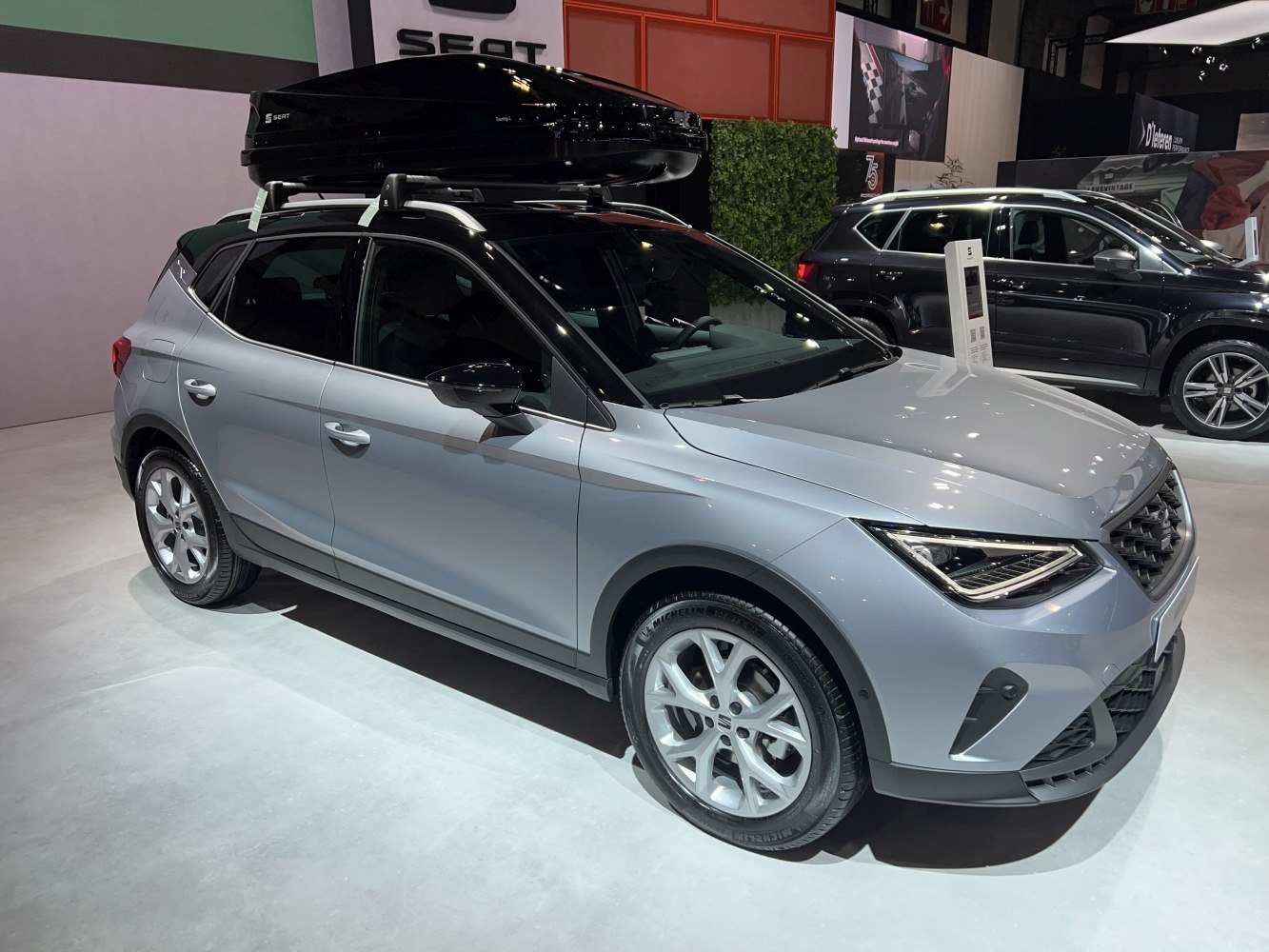 Modern compact SUV with roof cargo box and sleek headlights
