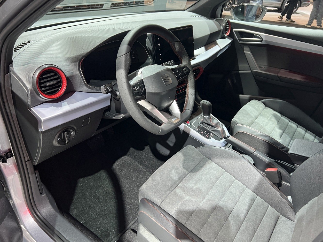 Car interior with steering wheel, dashboard, and front seats