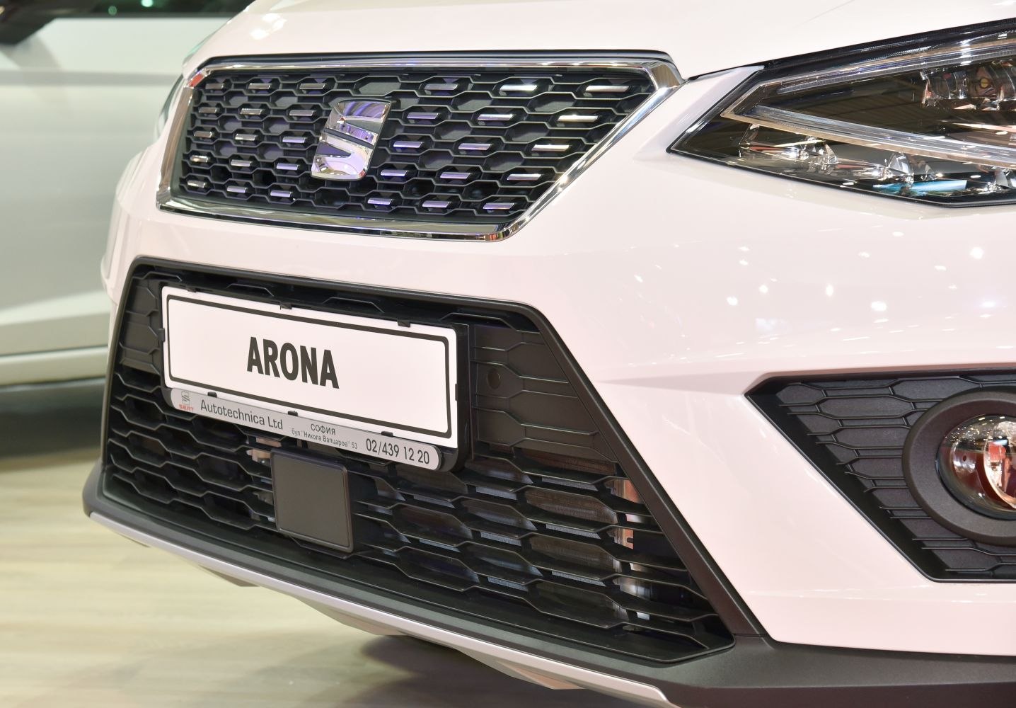 Close-up of front grille, headlight, and fog light with modern honeycomb pattern