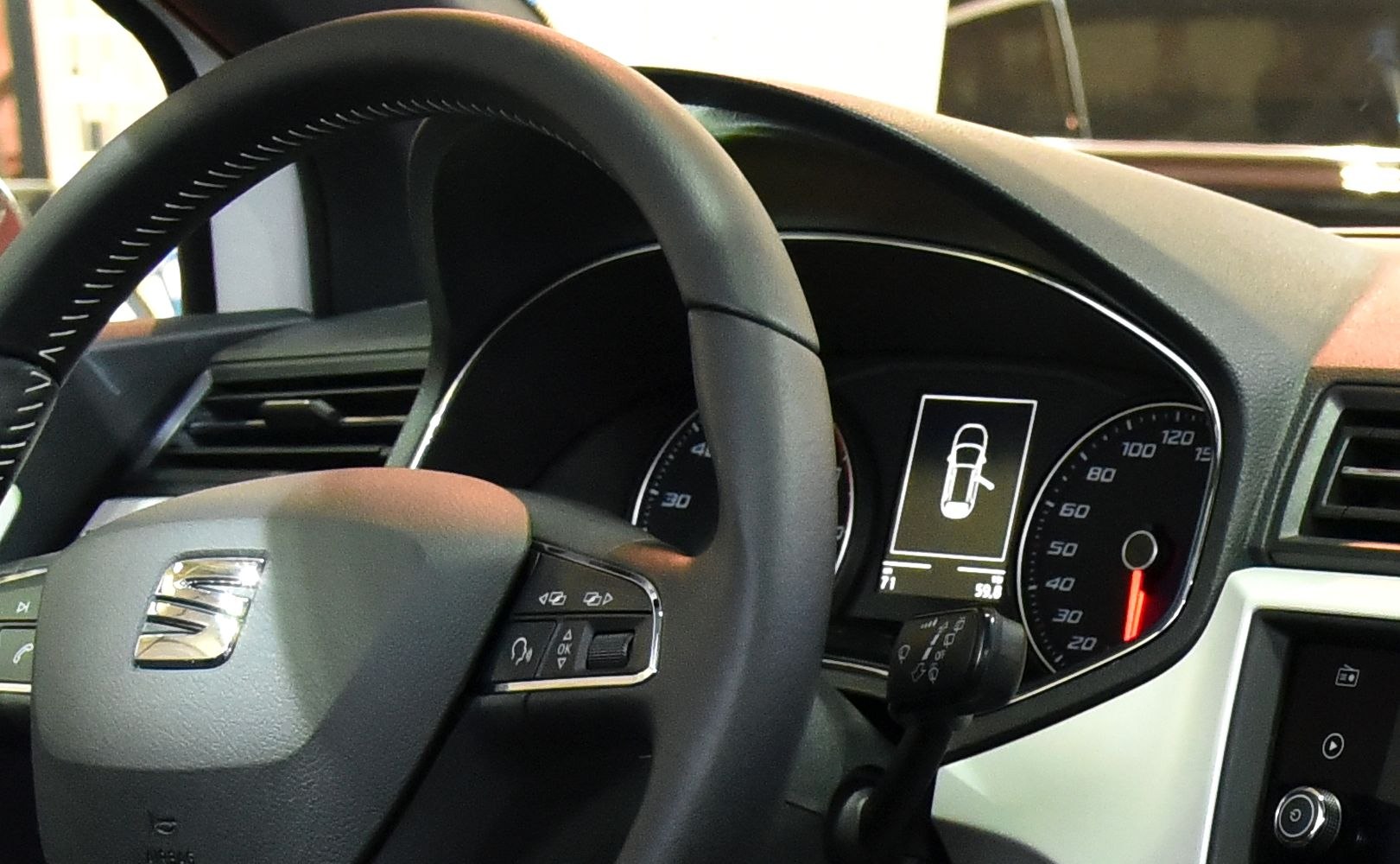 Steering wheel with controls and digital instrument cluster in dashboard