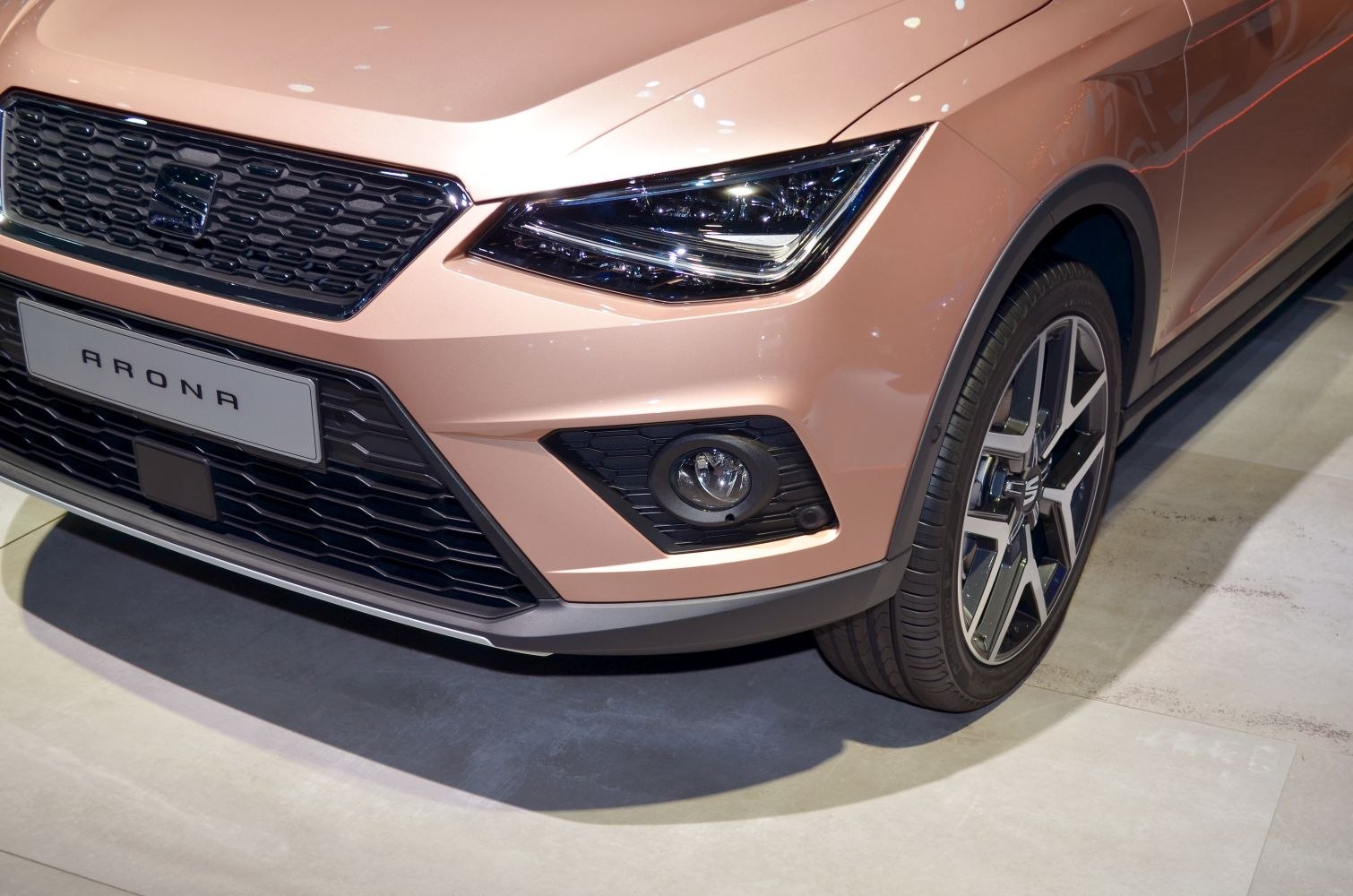 Close-up of front grille, headlight, fog light, and alloy wheel.