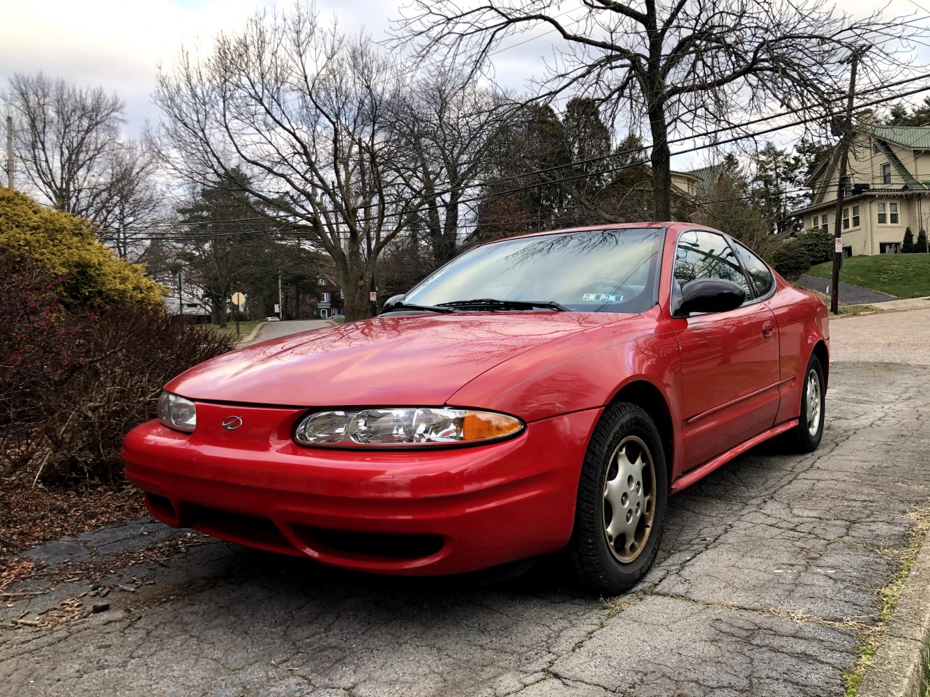 Red sleek coupe with aerodynamic body and distinct oval headlights.