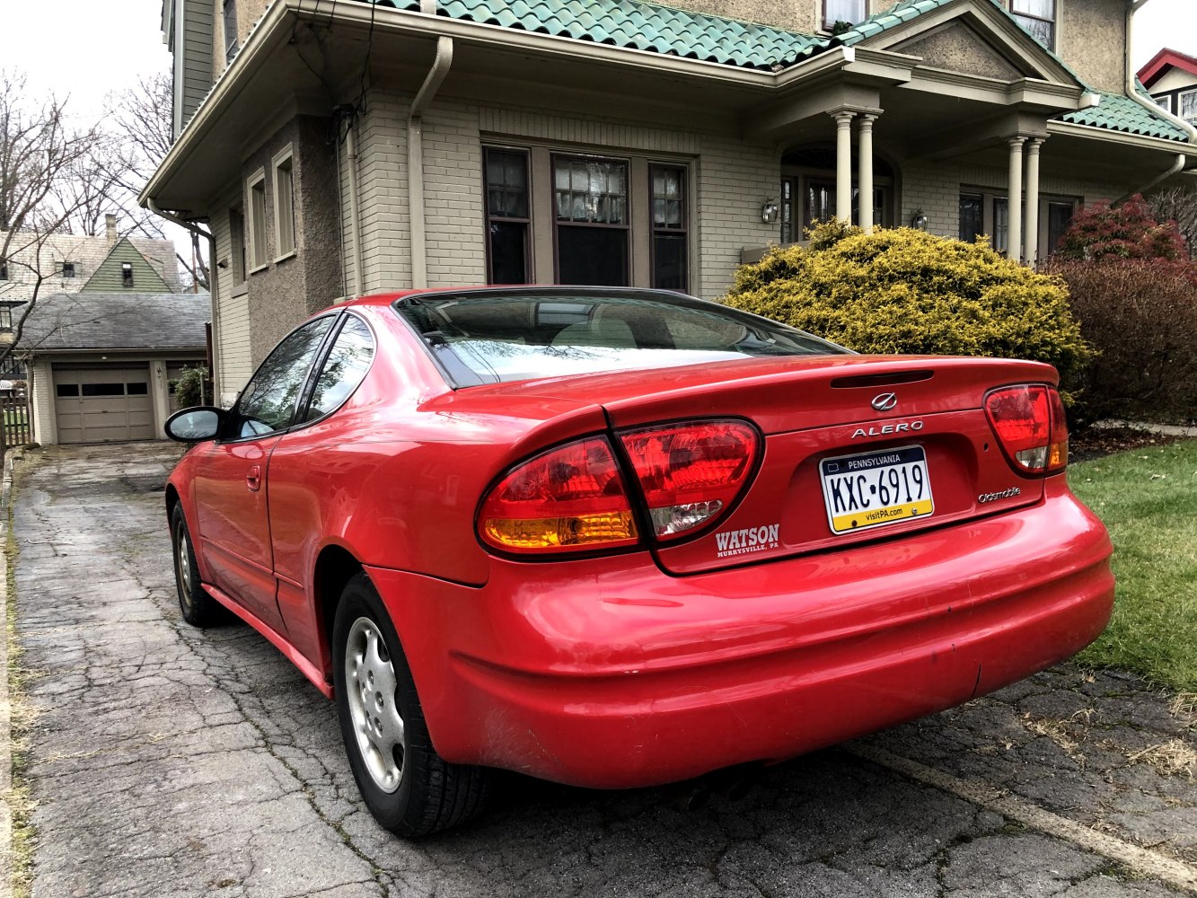 Red coupe rear view with tail lights, trunk, and bumper