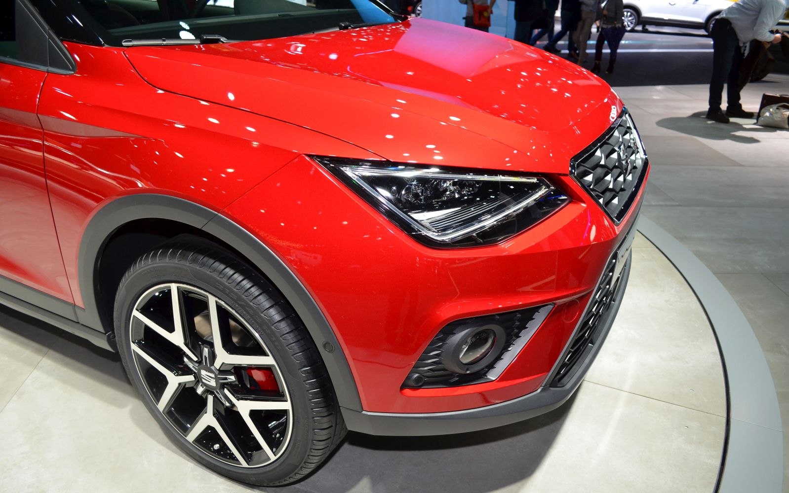 Sharp LED front headlights and stylish alloy wheel on red SUV front