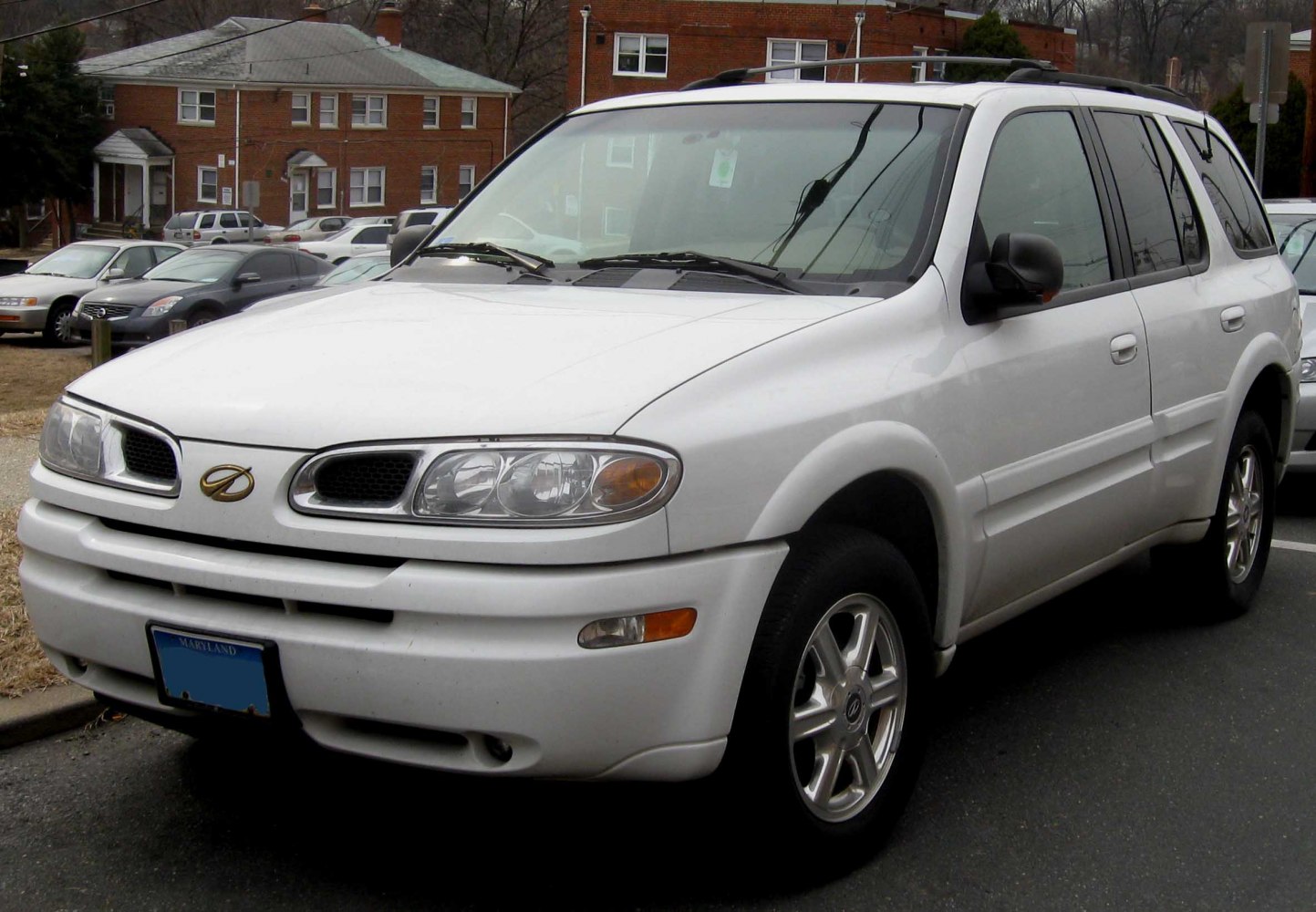 Front-side view of white SUV with distinct headlights and alloy wheels