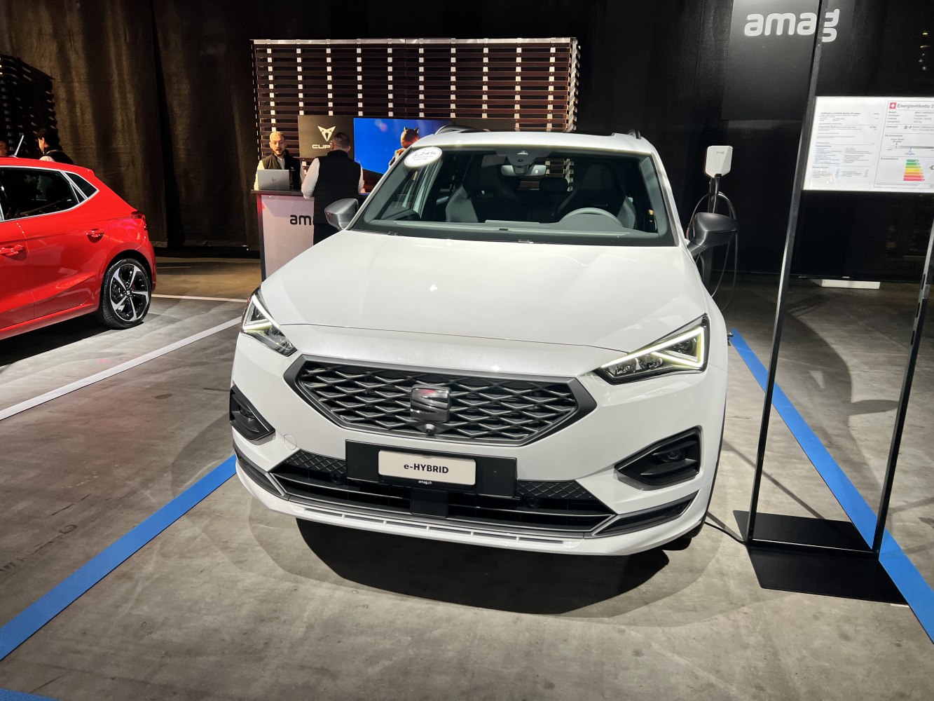 Angular headlights and geometric grille of a white e-HYBRID SUV front view