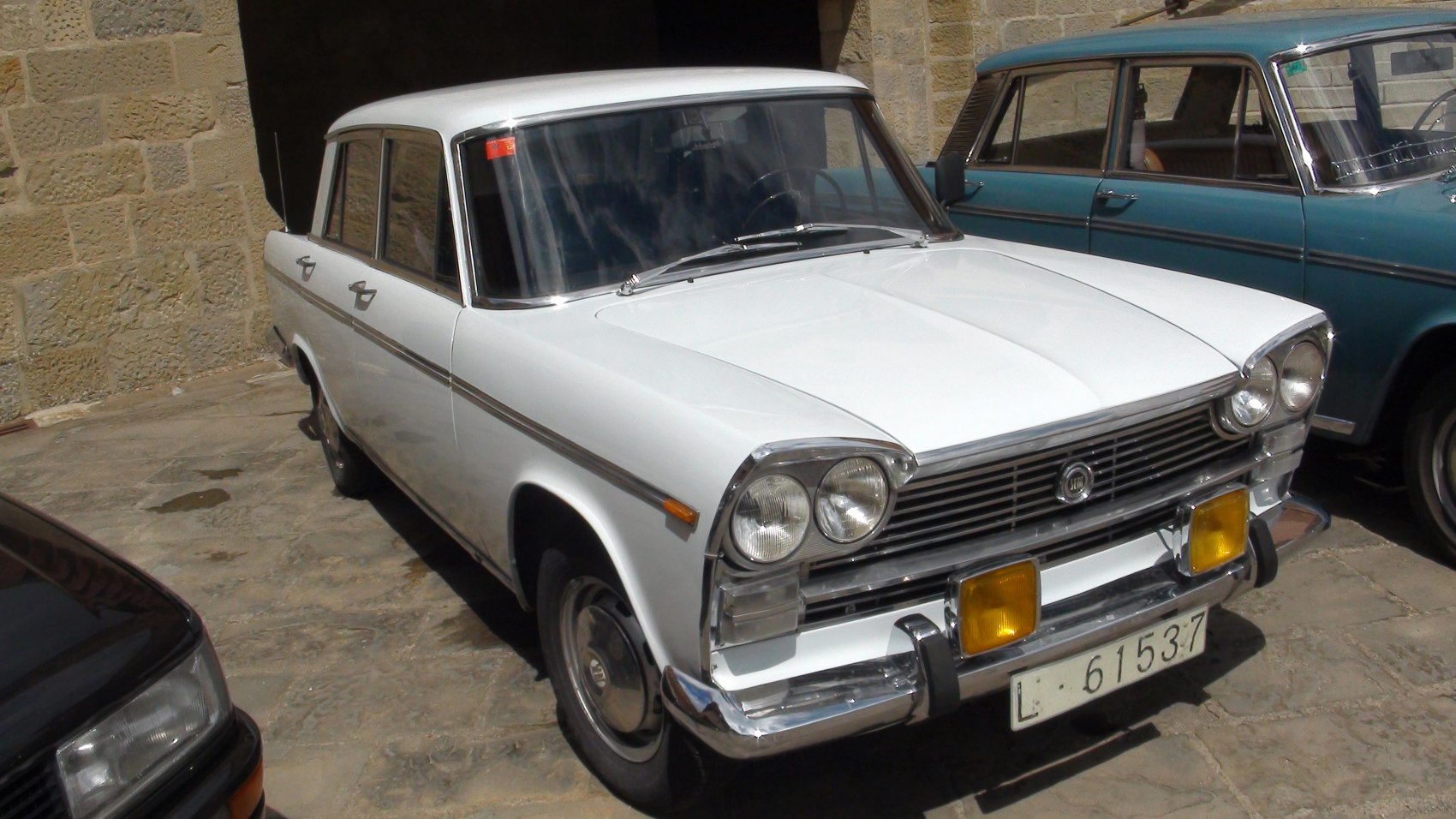 Vintage white sedan with dual round headlights and chrome trim