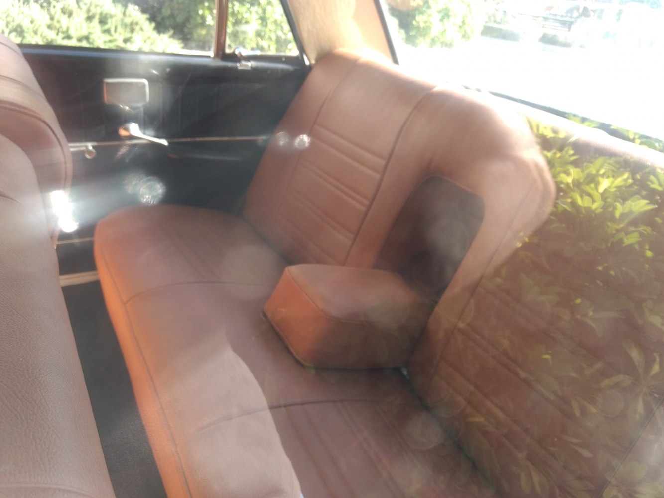 Brown leather rear seat with fold-down armrest and door handle