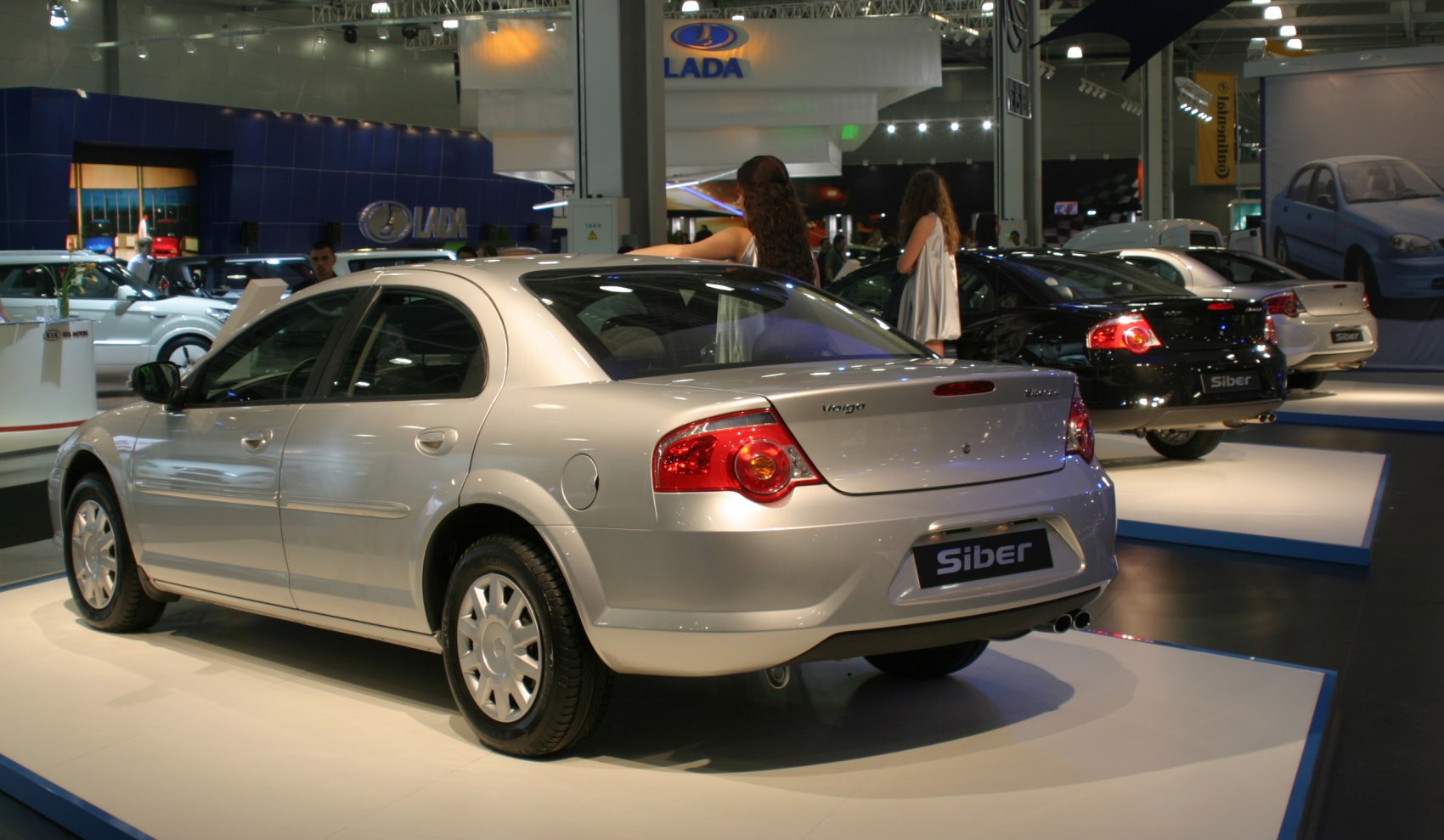 Rear side view of a silver sedan with round taillights and dual exhaust.