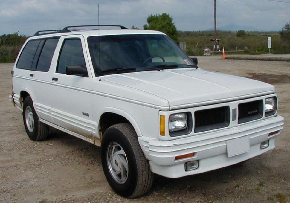 Front angled view of a white SUV with square headlights and a robust grille