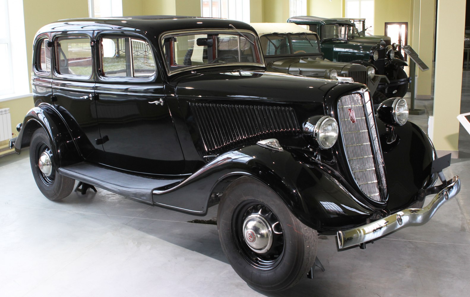 Vintage luxury sedan with chrome vertical grille and round headlights