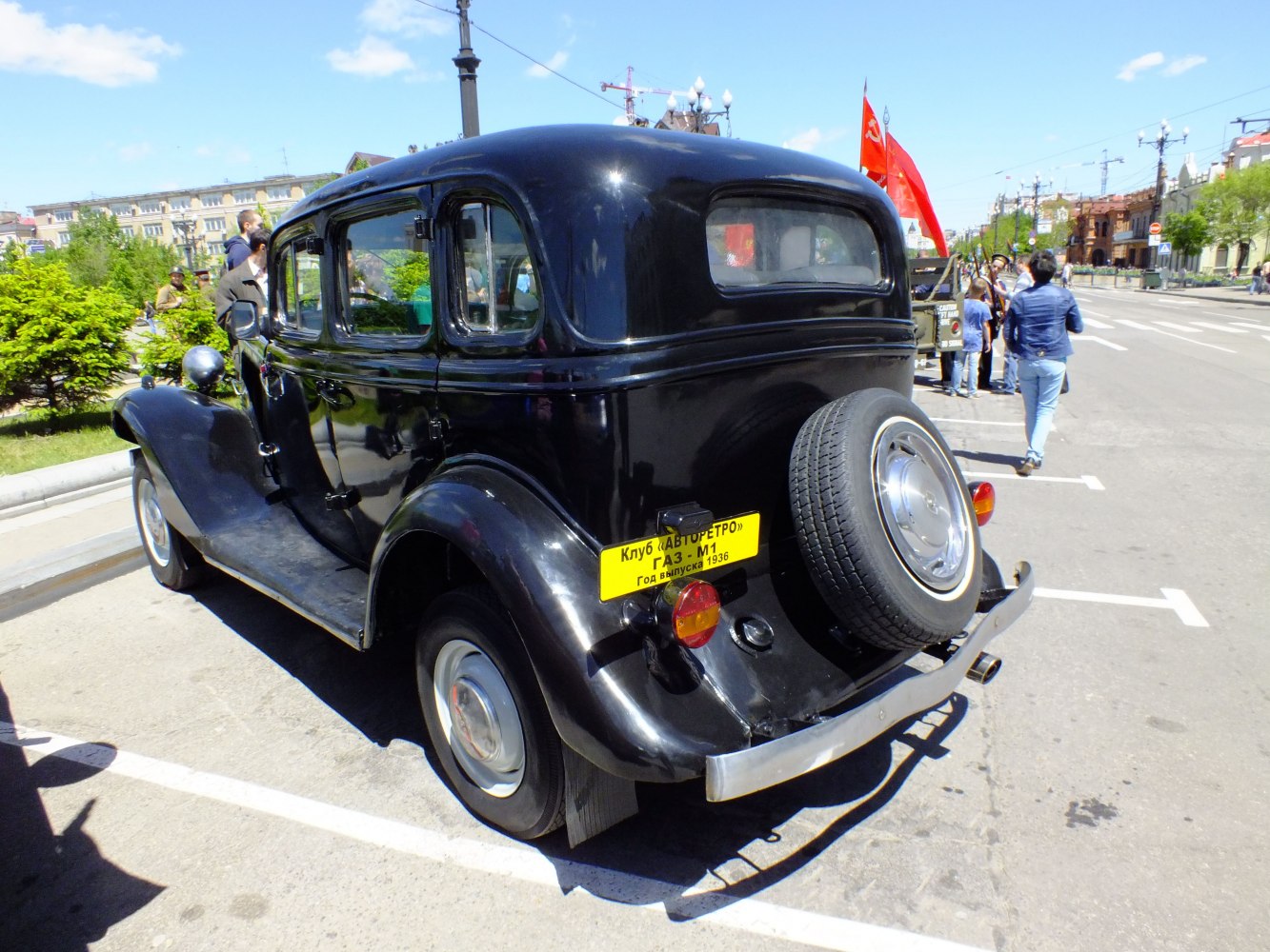 Vintage black sedan with rear spare tire and rounded classic design.