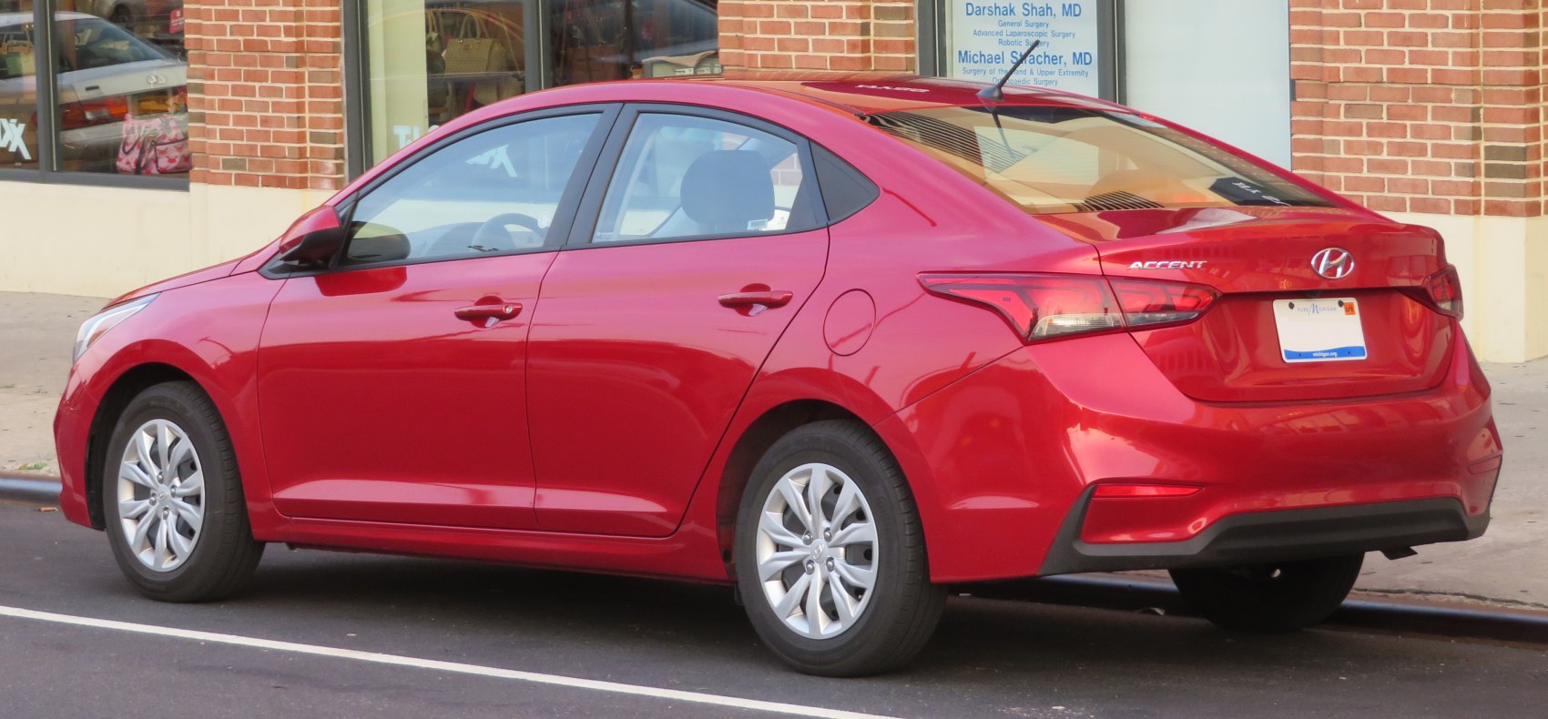 Red compact sedan rear side view with alloy wheels and modern design