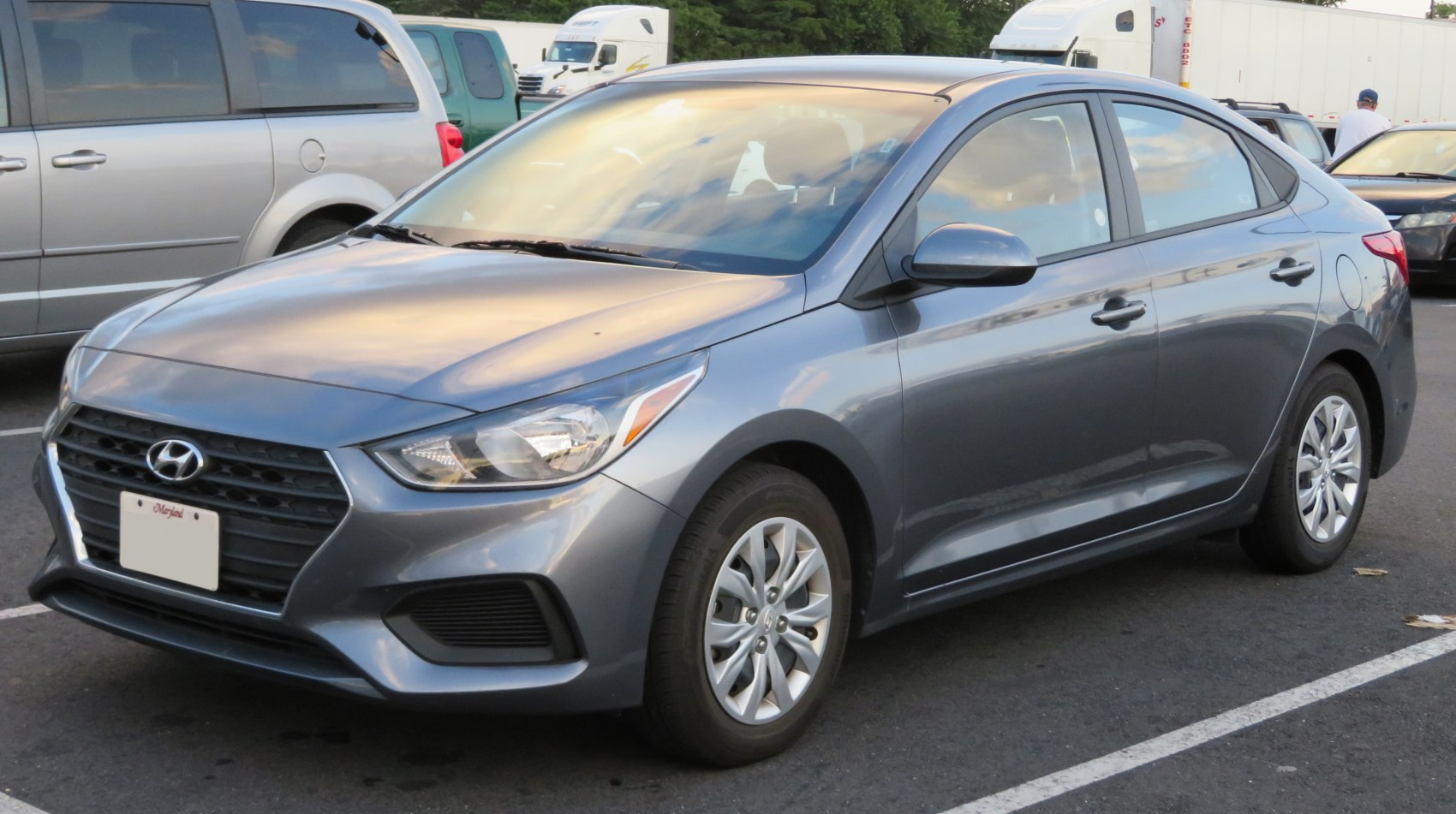Compact sedan in gray with modern headlights and grille, front-side view
