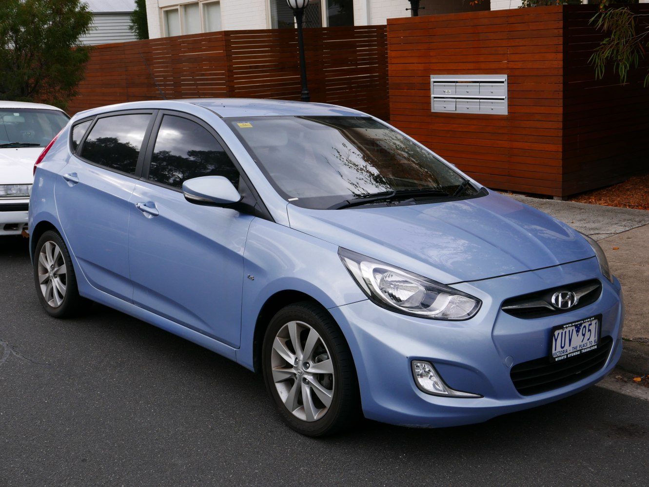 Front side profile of a sleek hatchback with distinctive headlights and tinted windows