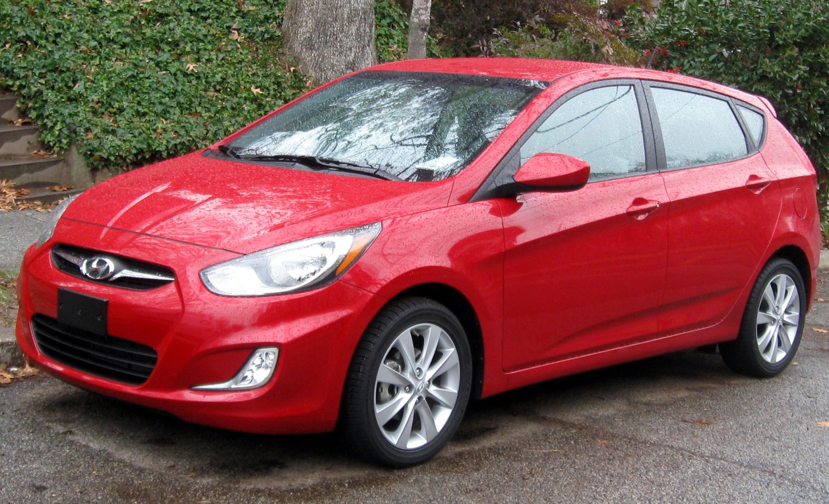 Red compact hatchback with angular headlights and five-door design