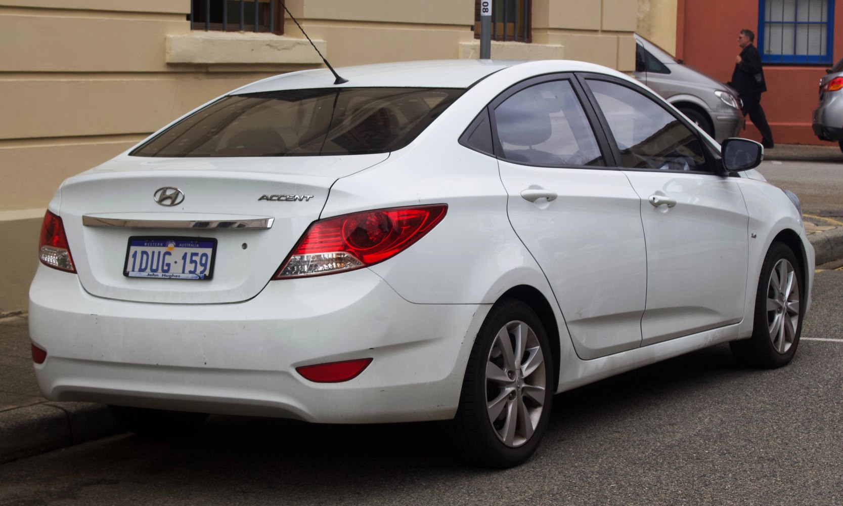 Rear side view of a white four-door sedan with alloy wheels and modern taillights