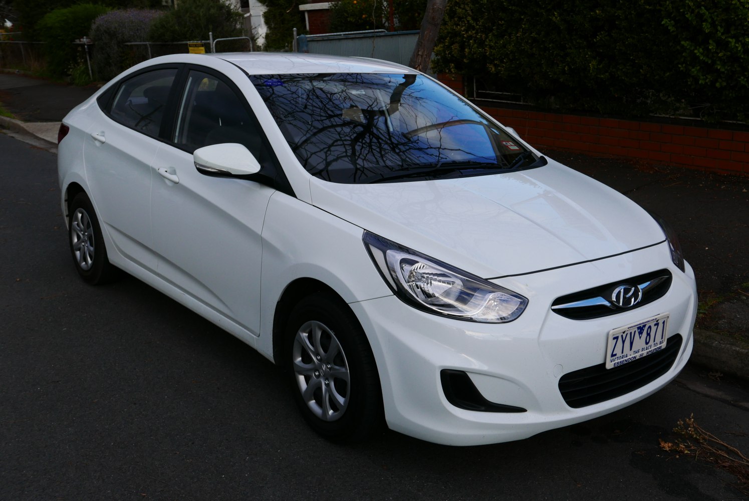 Front-side view of a white sedan with distinctive headlights and smooth body lines