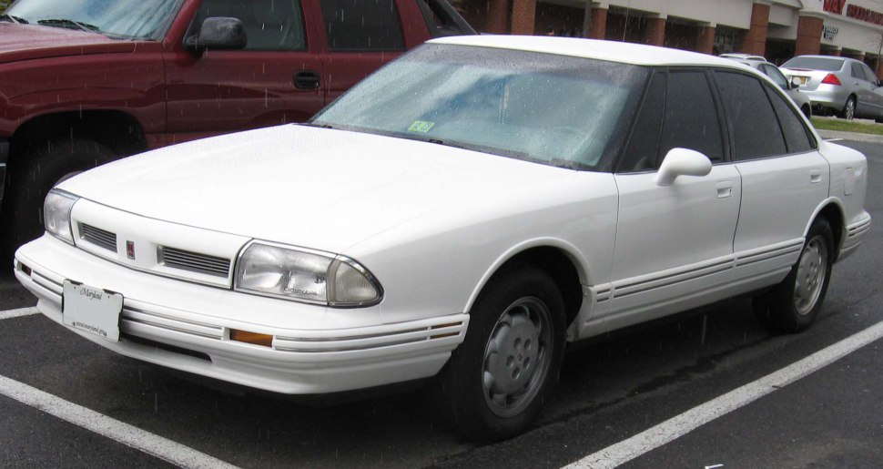 White four-door sedan with front grille and headlight design.