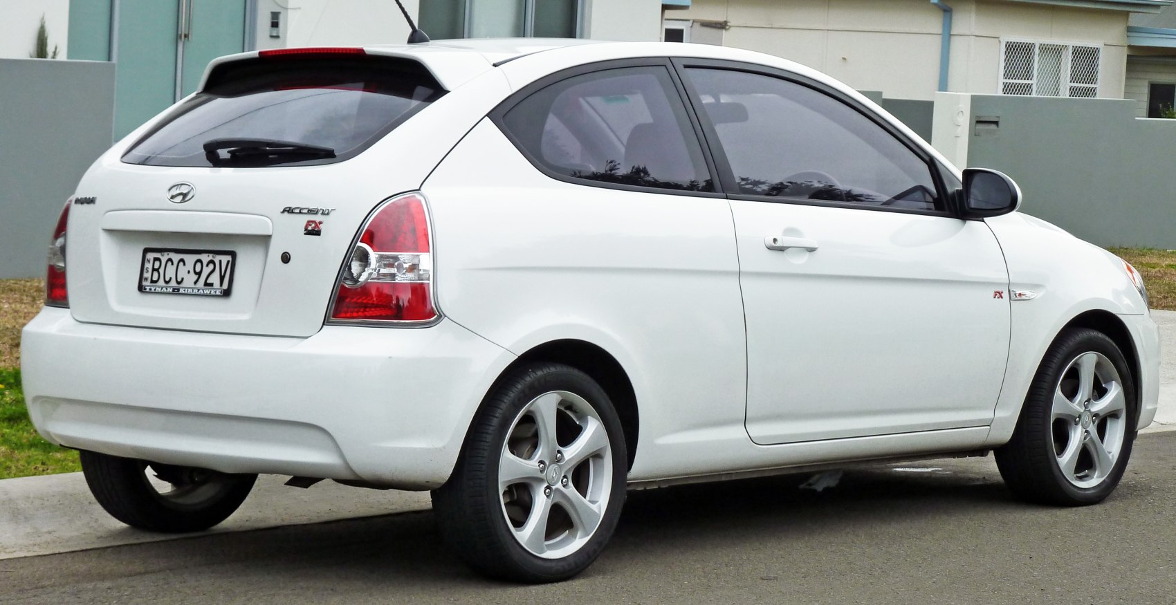 Rear side view of a white compact hatchback with alloy wheels and tinted windows