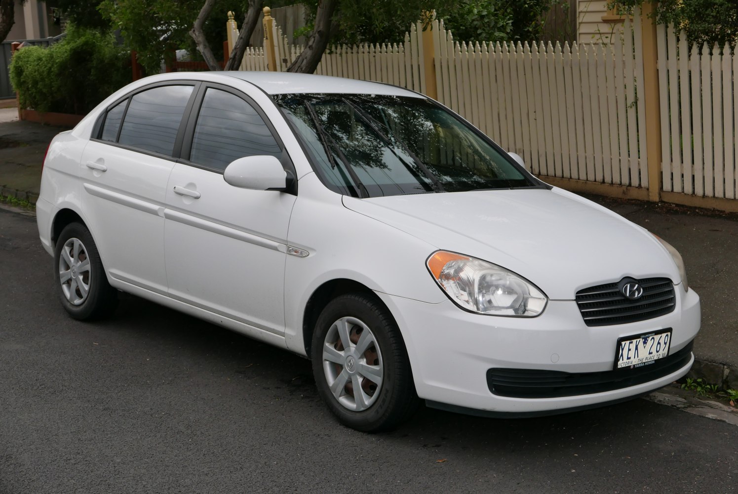 White sedan front-side view with headlights and side mirrors