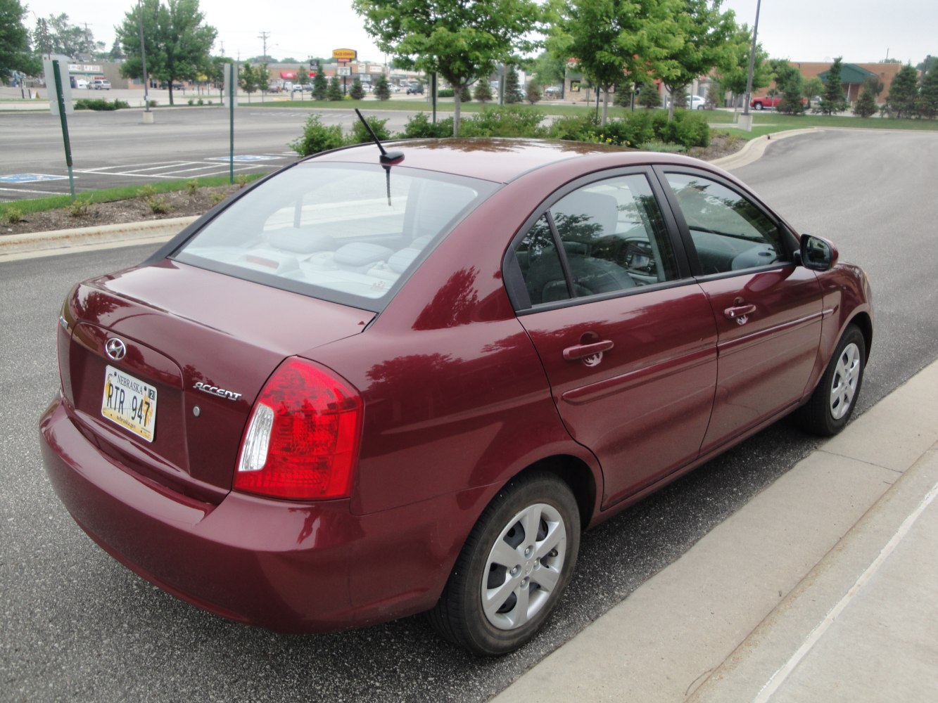 Rear and side profile of a compact four-door sedan with rounded tail lights.