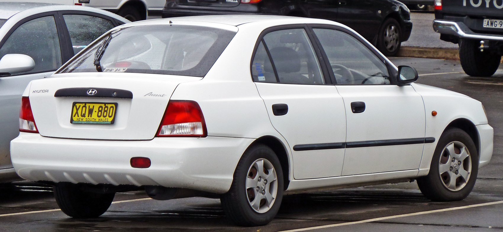 Rear and side profile of a white sedan with red taillights and black trim