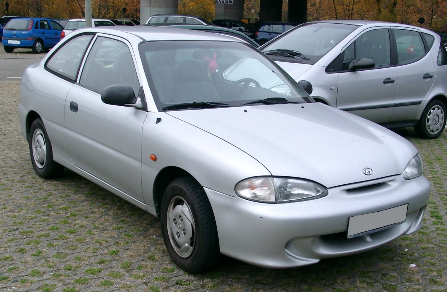 Compact silver hatchback with rounded headlights and simple design