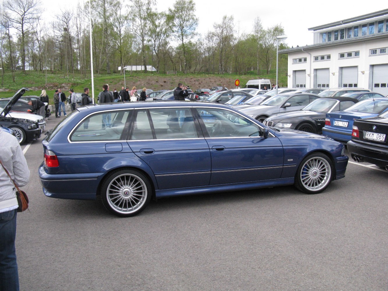 Side profile of a dark blue estate with distinctive multi-spoke Alpina alloy wheels.