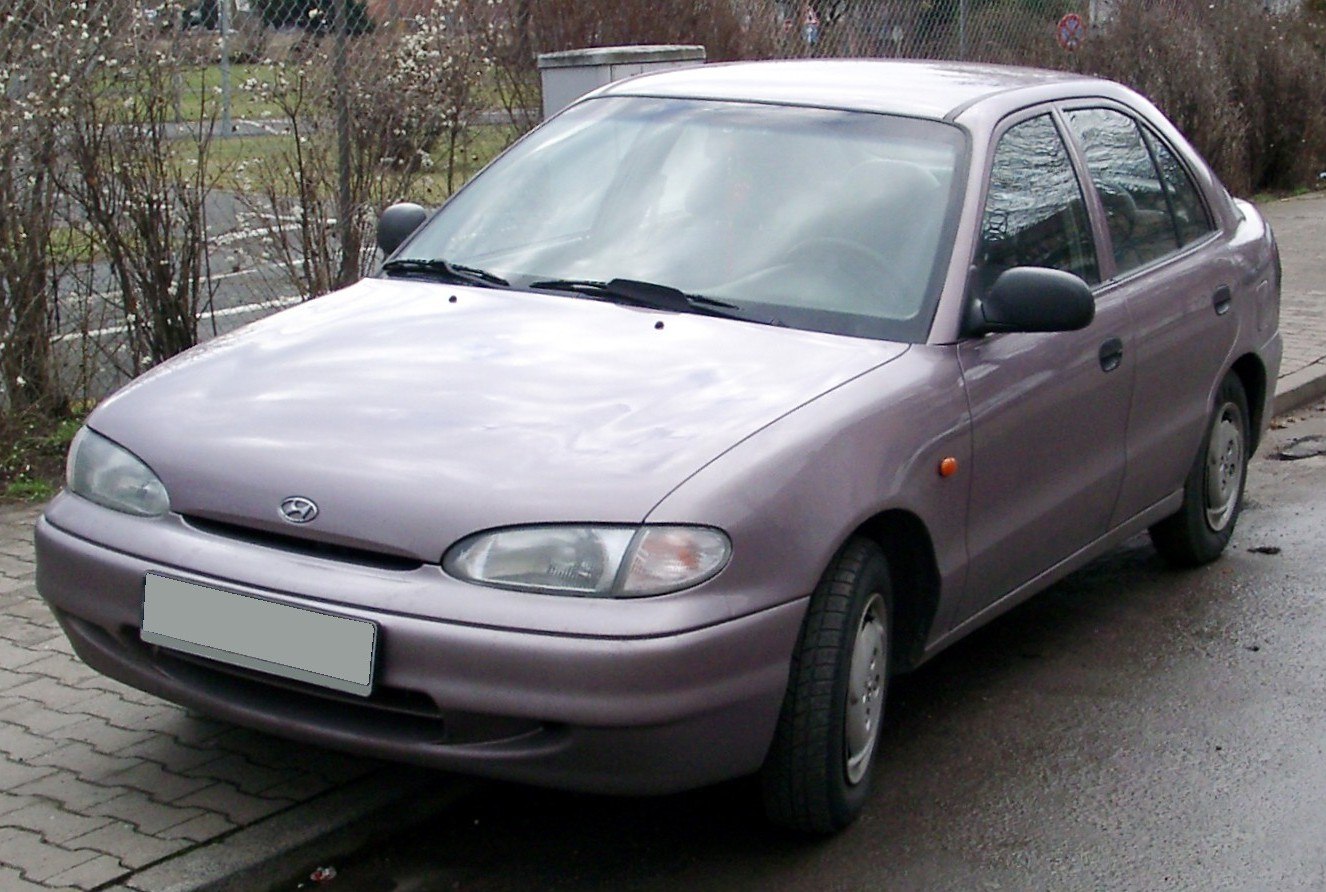 Compact hatchback front and side view with curved headlights and smooth body.